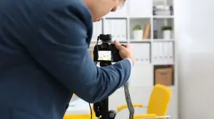Male arms in suit mount camcorder to tripod