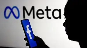 March 16, 2022, Brazil. In this photo illustration, a woman holds a smartphone with the Facebook logo displayed on the screen with the Meta Platforms logo displayed in the background.