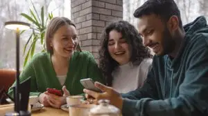 group of people laughing at a phone after watching a funny social media trend