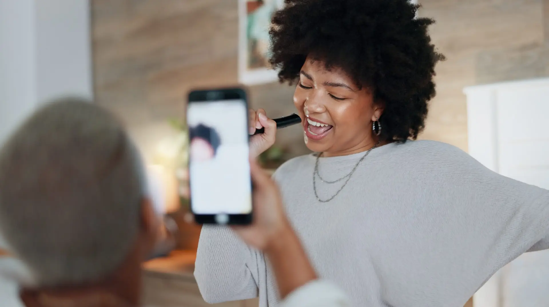 woman singing and a man recording her for a tiktok trend