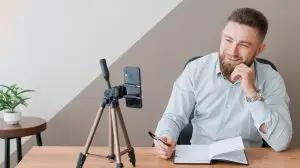 Young bearded man with smartphone and timetable notepad. Close-up business