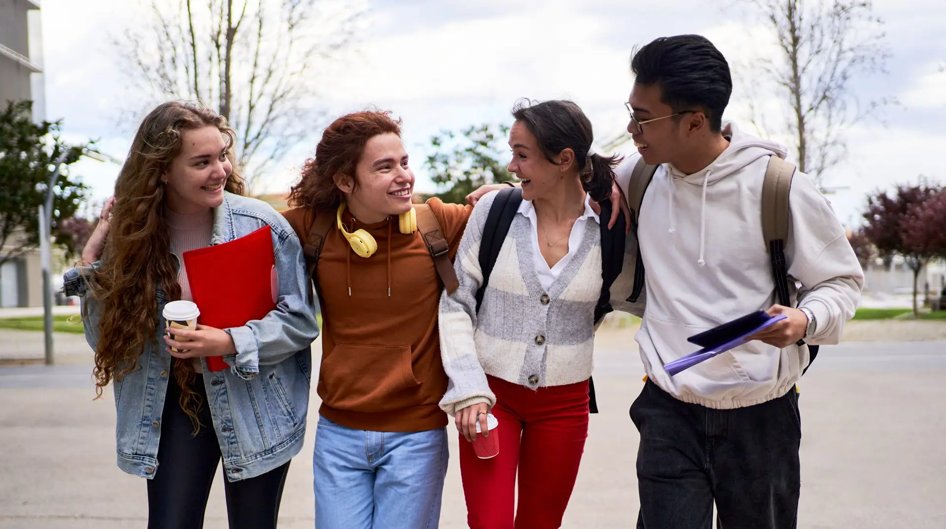 Diverse group of students walking outside the university, talking and having fun.