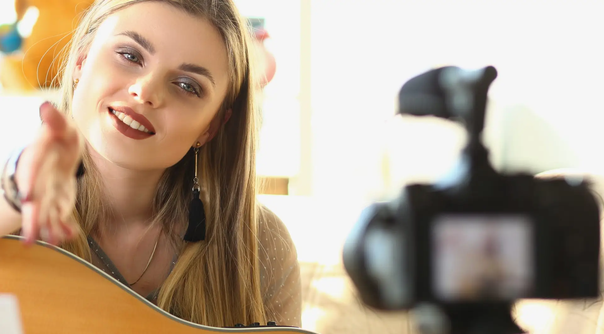 Female musician recording guitar teaching videos closeup