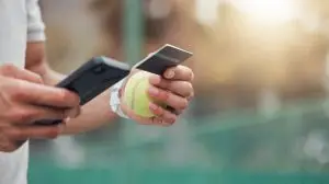 Man, hands and phone with credit card for online shopping, tennis and sports payment on the court. Hand of male person or athlete on mobile smartphone banking app for ecommerce, sport or purchase