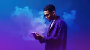 Man Using Phone On A Vibrant Purple Background. Сoncept Technology Addiction, Vibrant Color Palettes, Modern Communication, Digital Age, Abstract Backgrounds.