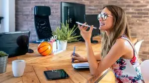 Office worker talking mobile phone with speaker