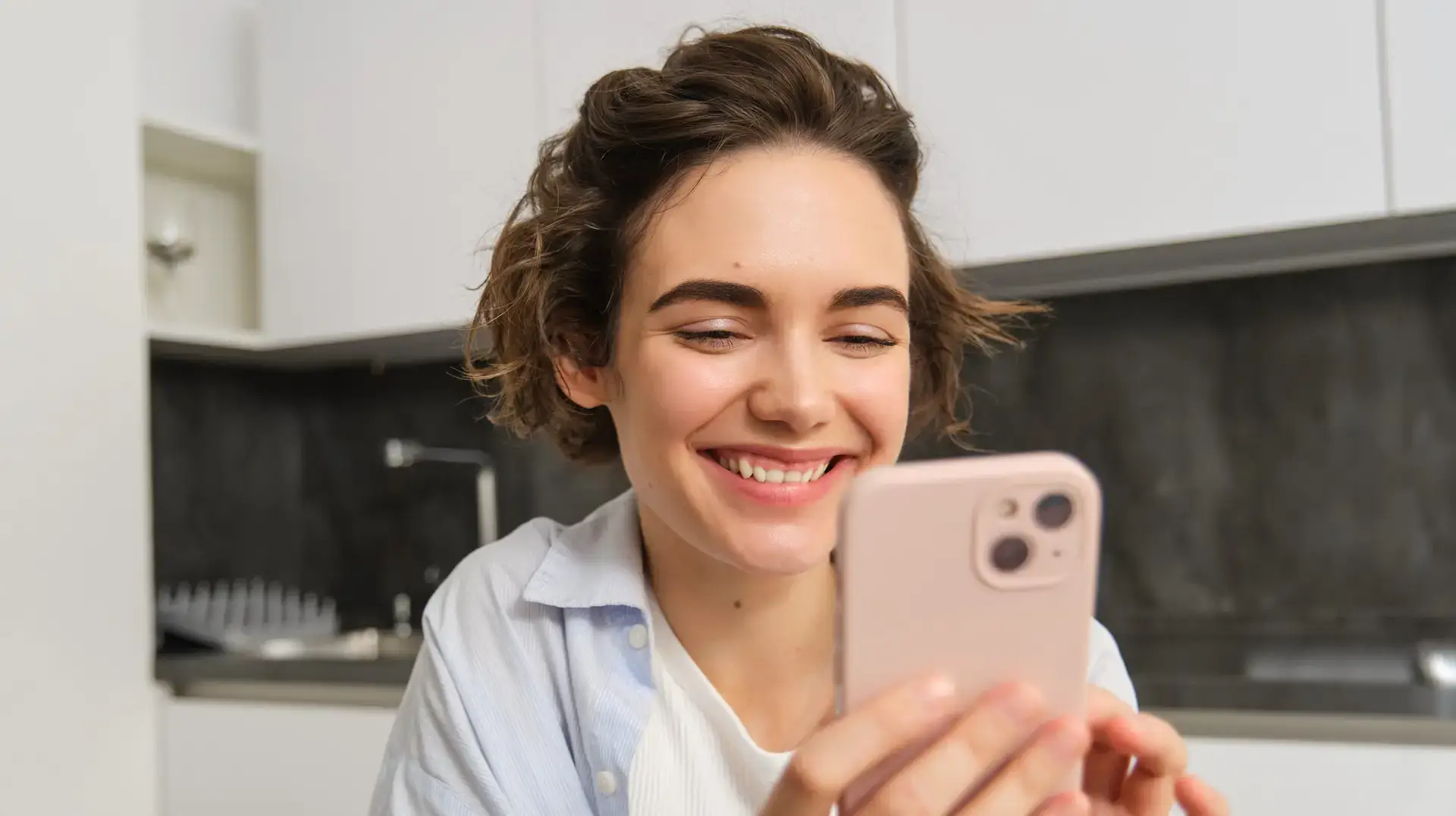 Portrait of beautiful woman at home, holding smartphone, online shopping from mobile phone app