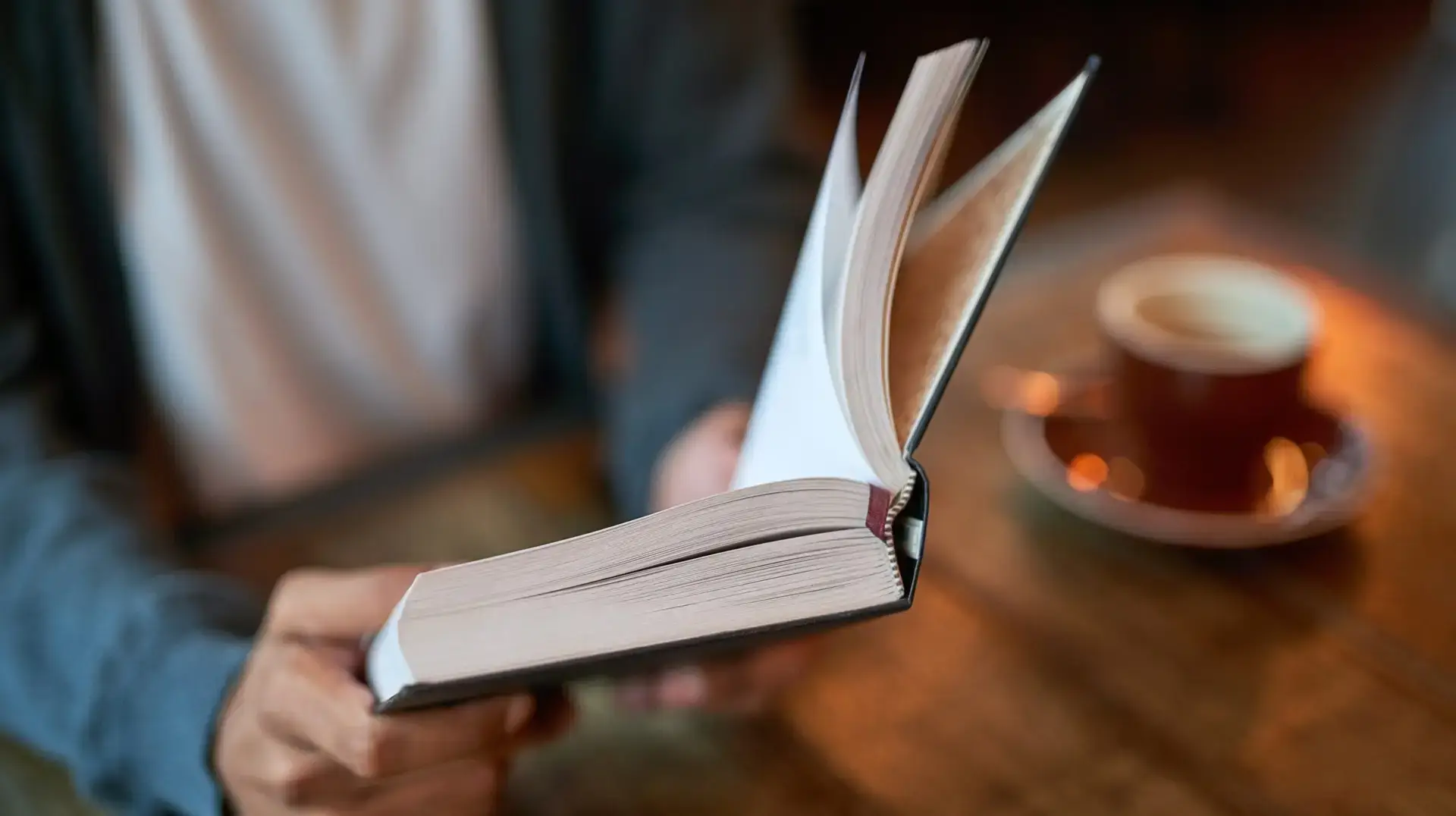 Hands,,Person,And,Book,With,Coffee,At,Cafe,In,Table