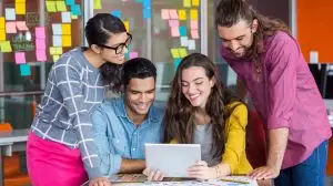 Smiling graphic designers discussing over digital tablet