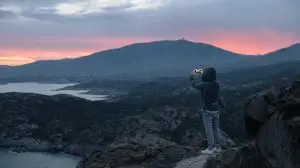 man makes photo of epic landscape sunset