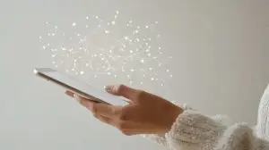 Woman in a cozy sweater interacting with a tablet, surrounded by abstract digital elements