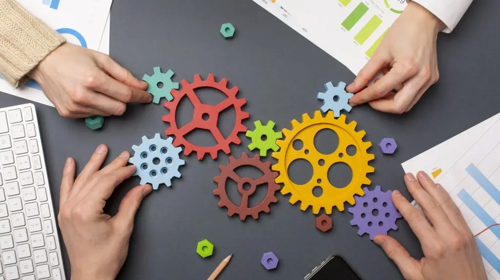 A graphic of gears and hands over a table, portraying a methodical and strategic marketing process