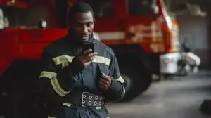 Portrait,Of,A,Firefighter,Standing,In,Front,Of,A,Fire