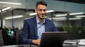 Smiling,Young,Middle,Eastern,Businessman,Sitting,At,Worktable,At,Modern
