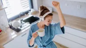 Young,Woman,Listening,Music,And,Enjoying,Cup,Of,Coffee,At