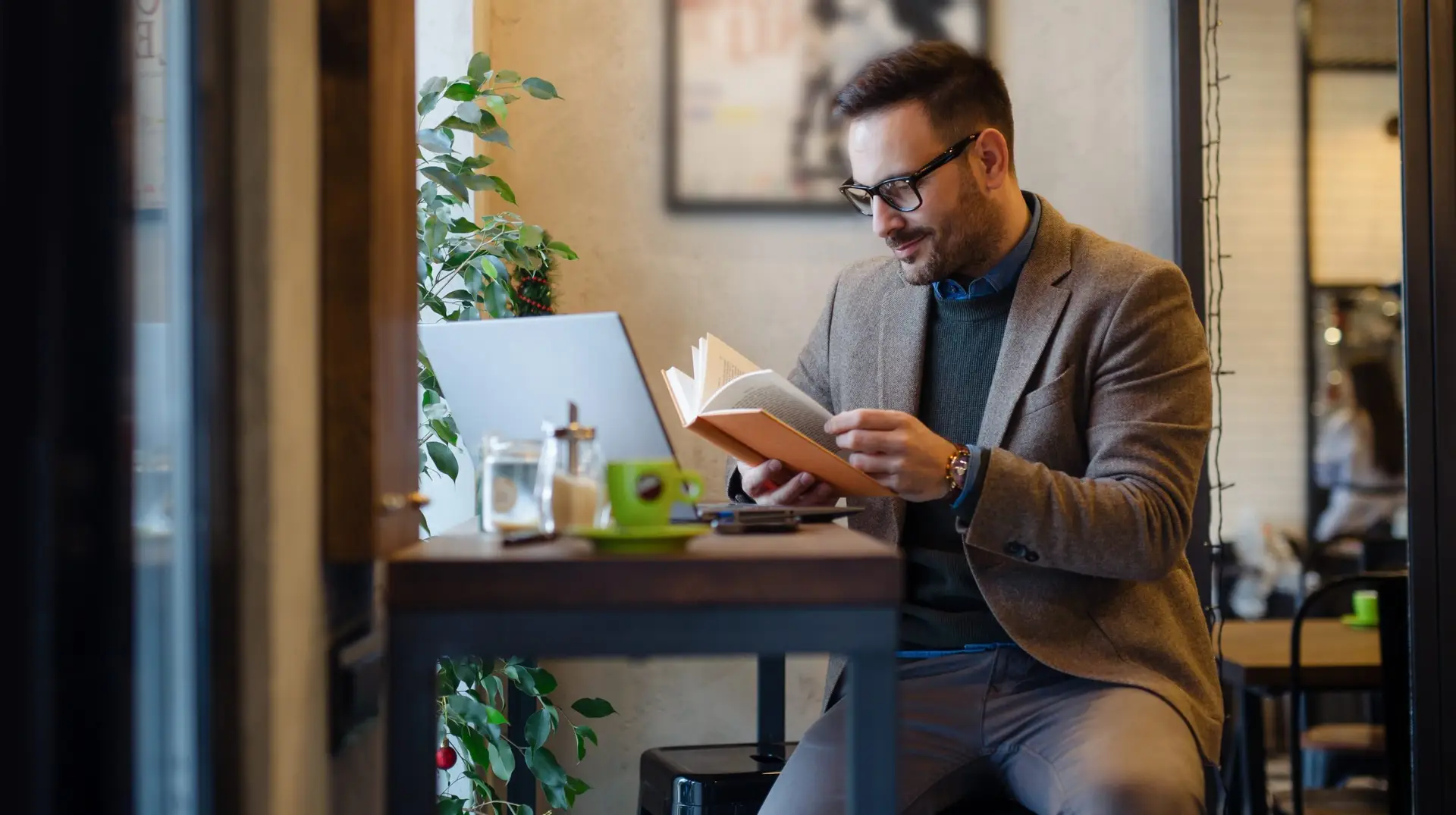 Businessman,Reading,Book,While,Sitting,In,Cafe
