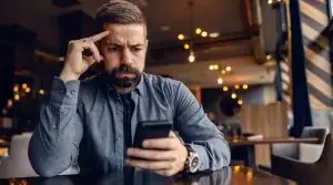 A,Worried,Man,Is,Sitting,In,Cafeteria,And,Looking,At