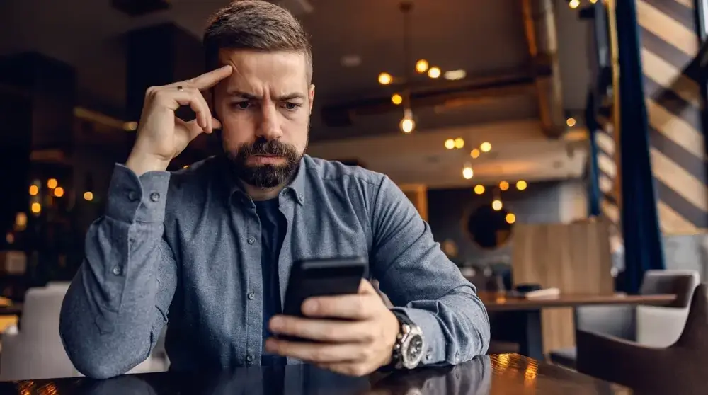 A,Worried,Man,Is,Sitting,In,Cafeteria,And,Looking,At