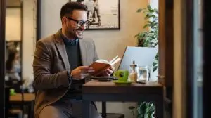 Businessman,Reading,Book,While,Sitting,In,Cafe