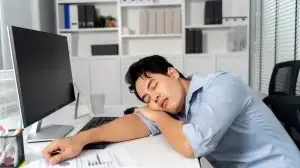 Young,Adult,Asian,Businessman,Sleeping,On,His,Desk,With,A