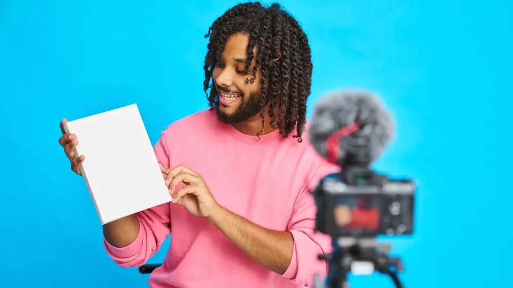 A,Man,Shows,A,Blank,Book,While,Recording,Himself,In