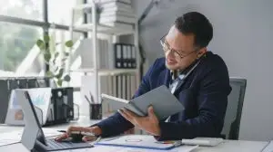 Asian,Accountant,Is,Working,In,His,Office,,Checking,Some,Numbers