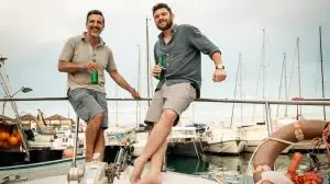 Two,Men,Relaxing,On,A,Yacht,With,Drinks,,Enjoying,A