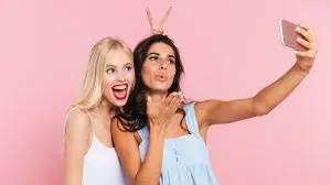 Young funny ladies making selfie and smiling isolated