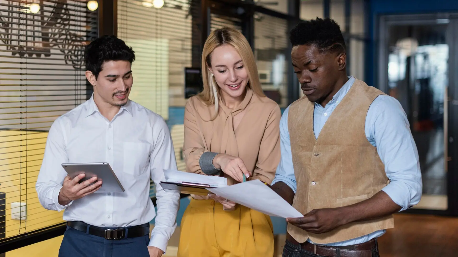 In the image, we see a lady telling a story while all 3 co-workers are looking at documents.