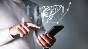 Entrepreneur launching a digital rocket ship from a smartphone to represent business scaling