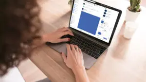 A girl with a laptop is posting in a local Facebook group.