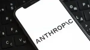 anthropic logo on an iphone with a keyboard in the background