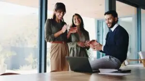 team of marketers looking at tech news on their phones in a room