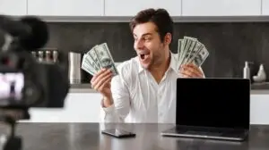 Man holding up money while recording a video for marketing purposes