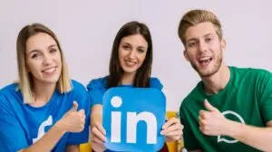 Group of marketers holding up the LinkedIn logo cutout