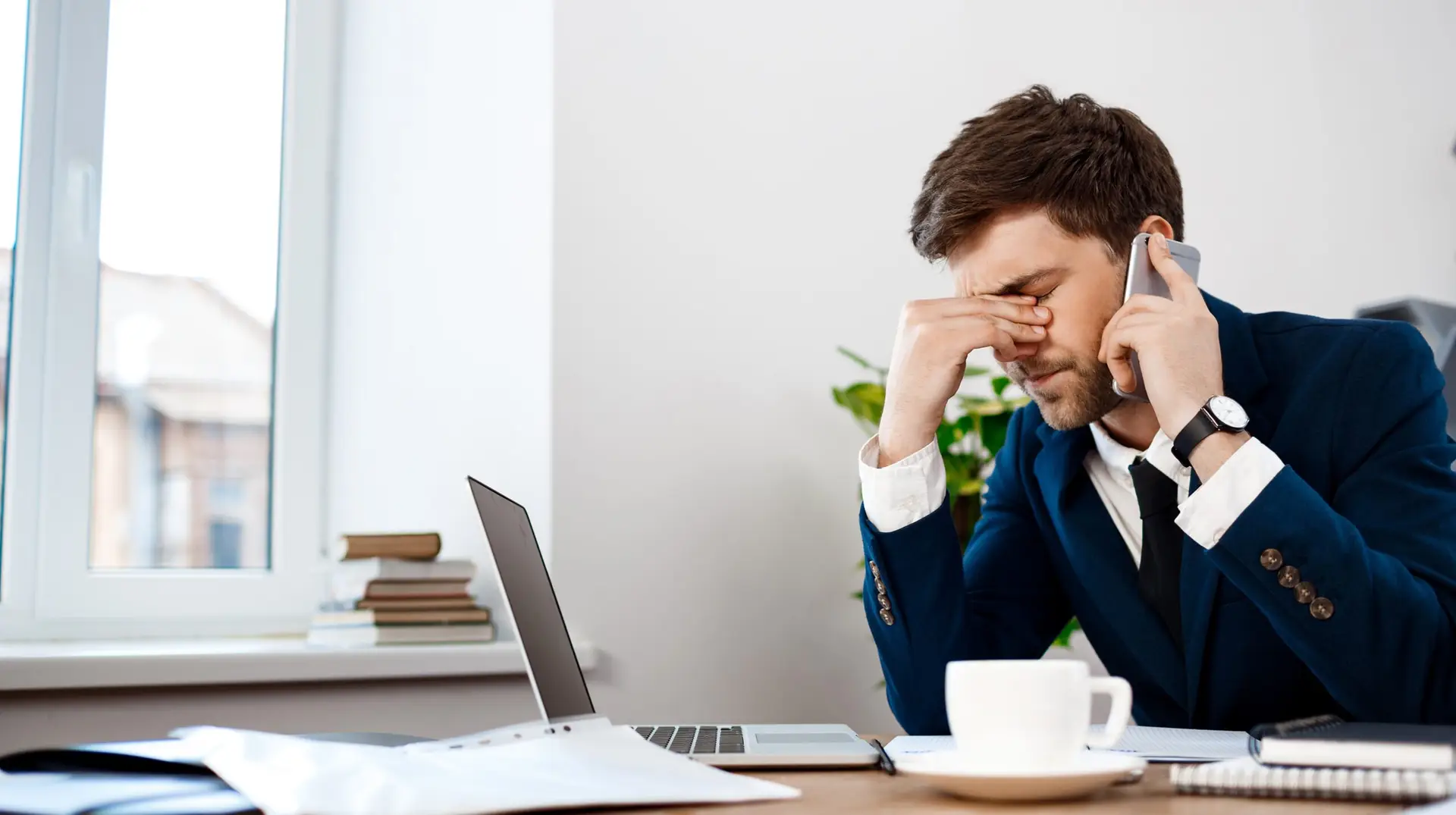 Upset young businessman speaking on phone