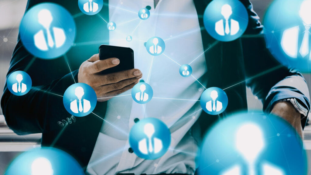 A person is holding a phone surrounded by connected LinkedIn account logos.
