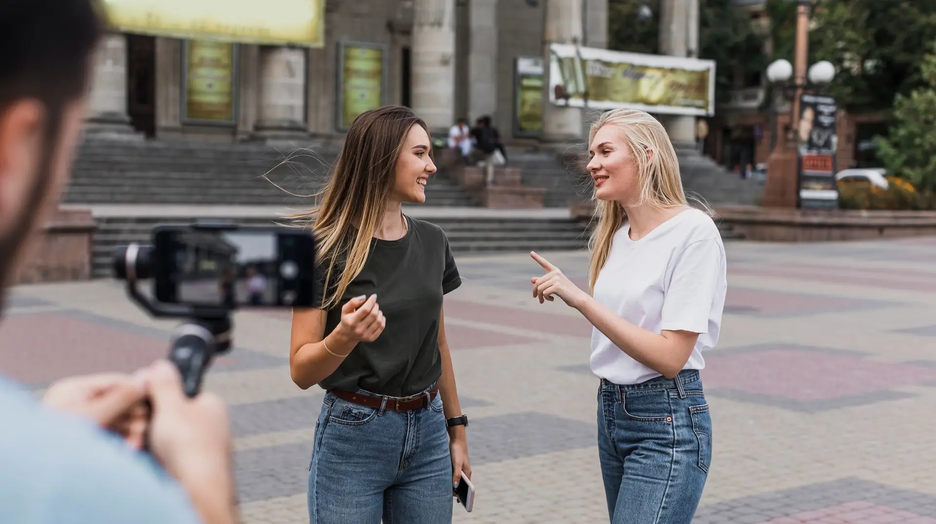Influencer woman interviewing another woman on the street while being recording on camera for social media
