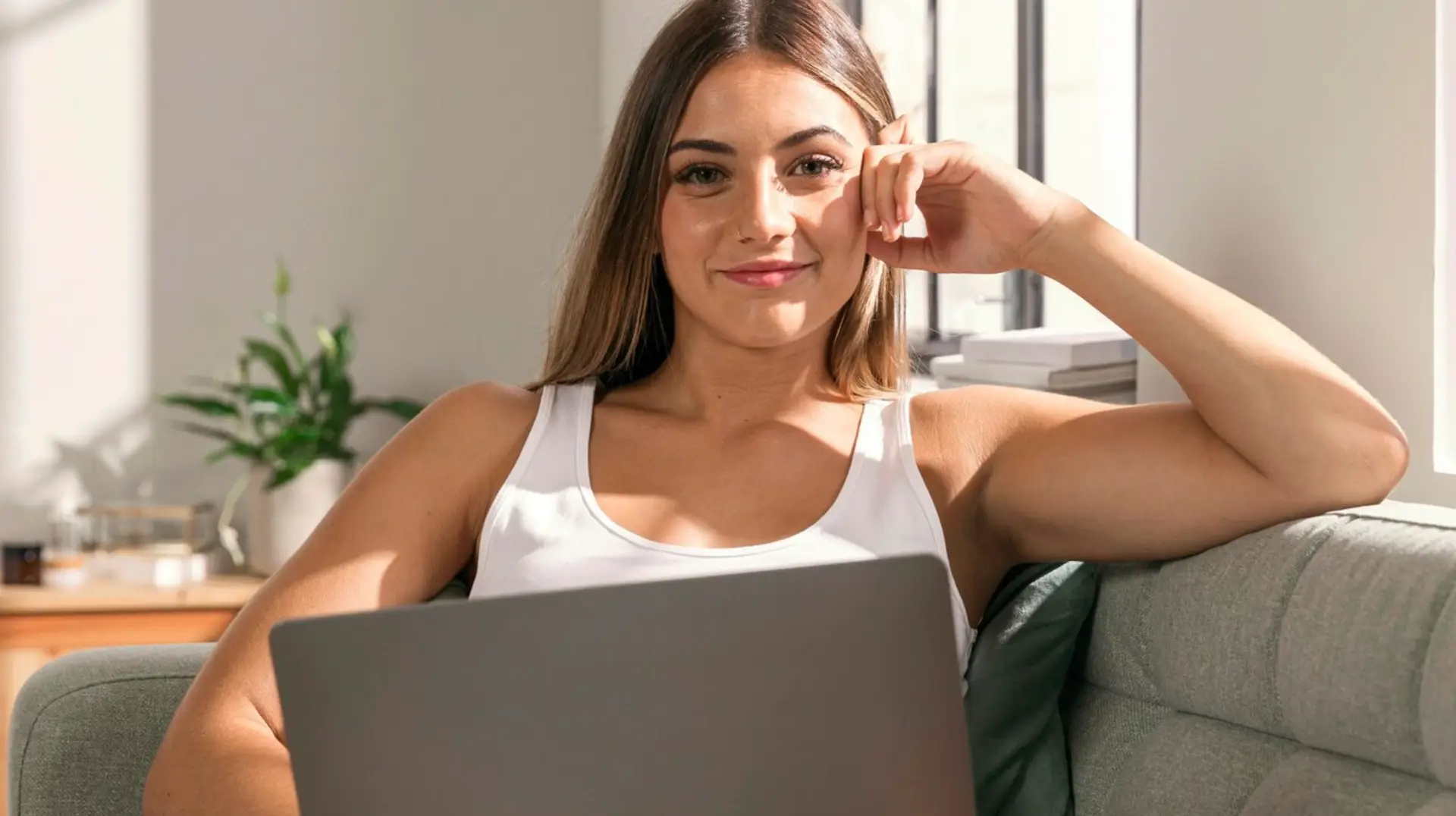 Female online coach sitting on a couch with her laptop